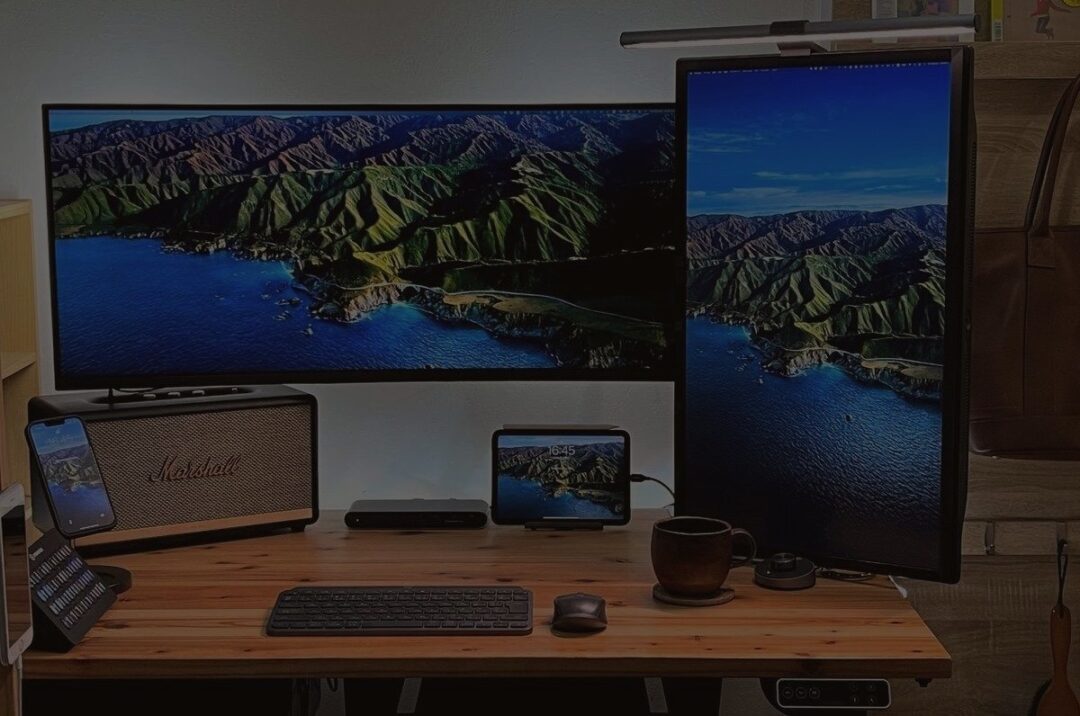 かなでもの杉無垢材の天板にFLEXISPOTの電動スタンディングデスク。M1 Pro MacBook Proとデュアル外部モニター。iPad mini 6 とiPhone 13 Pro デスク環境。